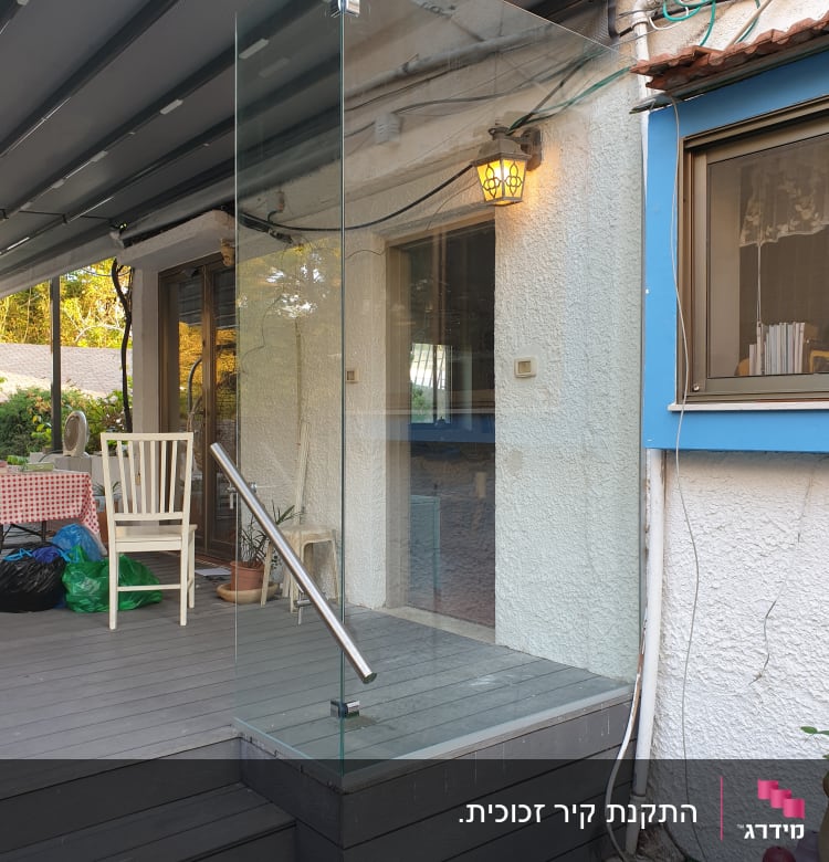 מעקה זכוכית עם ידית מתכת על מדרגות עץ